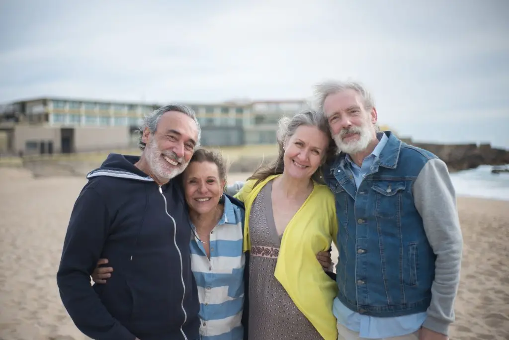A cheerful group of mature friends enjoying a day at the beach in Portugal, showcasing togetherness.