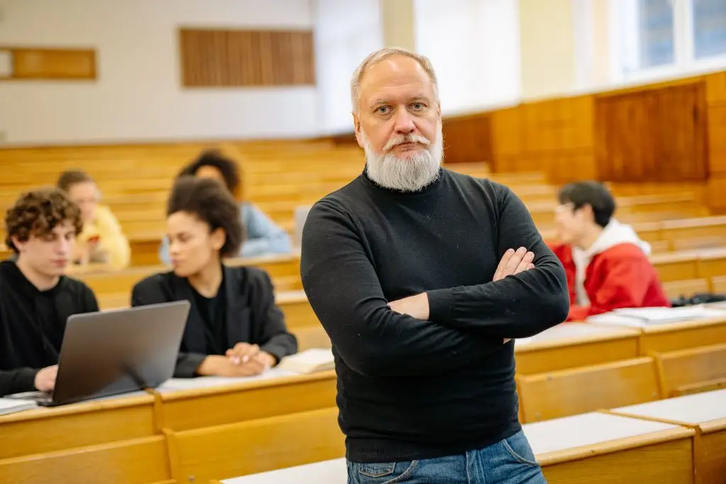 Confident professor in lecture hall with diverse students engaged in learning.